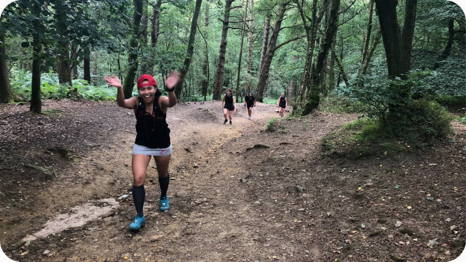 Female trail runner climbing a hill in the Surrey Hills.